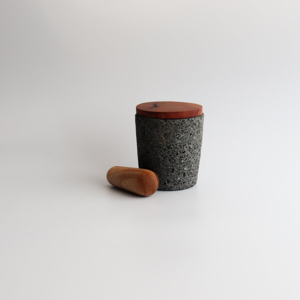 Studio CM | medium volcanic stone pestle with a wooden top and wooden top on a white background