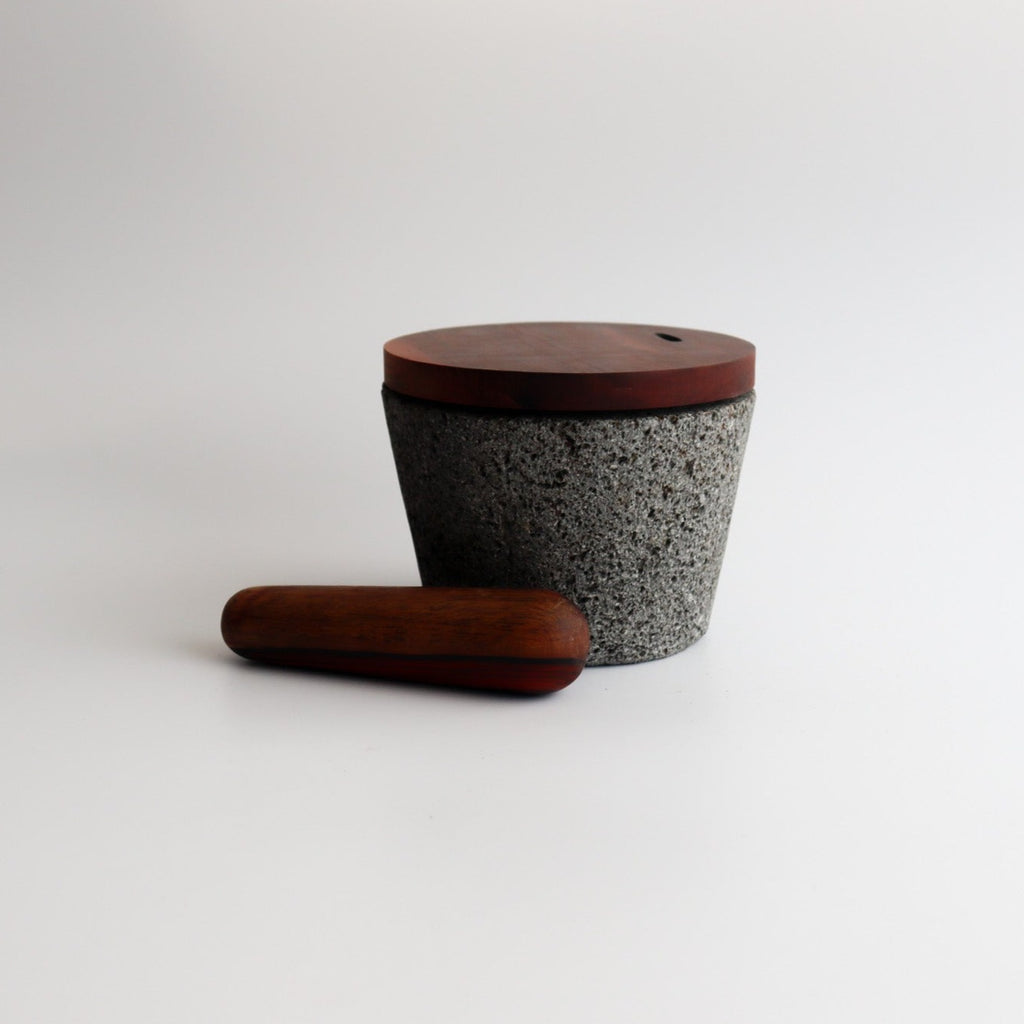 Studio CM | large volcanic stone mortar with a wooden top including a wooden pestle with a white background