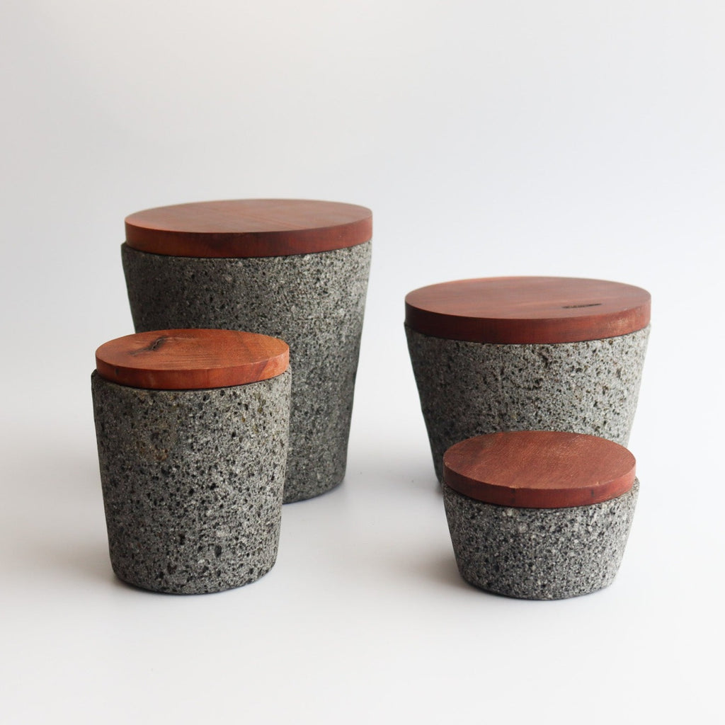 Studio CM | four different sizes of volcanic stone mortars with their wooden tops on a white background