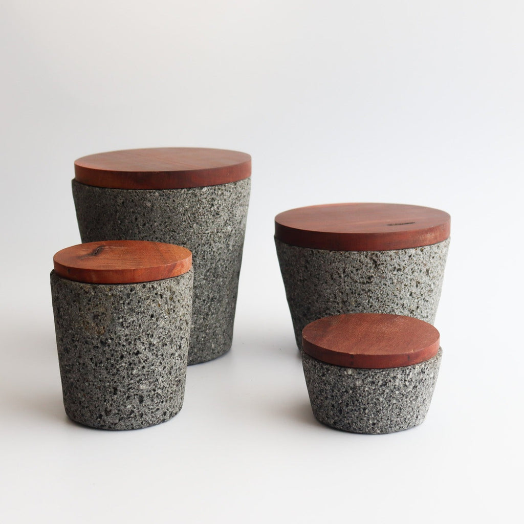 Studio CM | large volcanic stone mortar with a wooden top including a wooden pestle with a white background