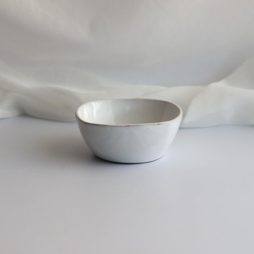 one white ceramic handmade bowl with a white linen background