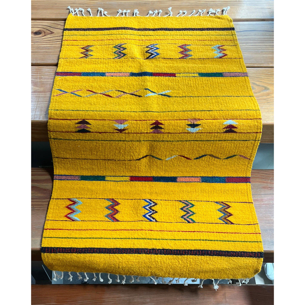 Studio CM | yellow zapotec rug with fringe ends decorated with vibrant traditional symbols