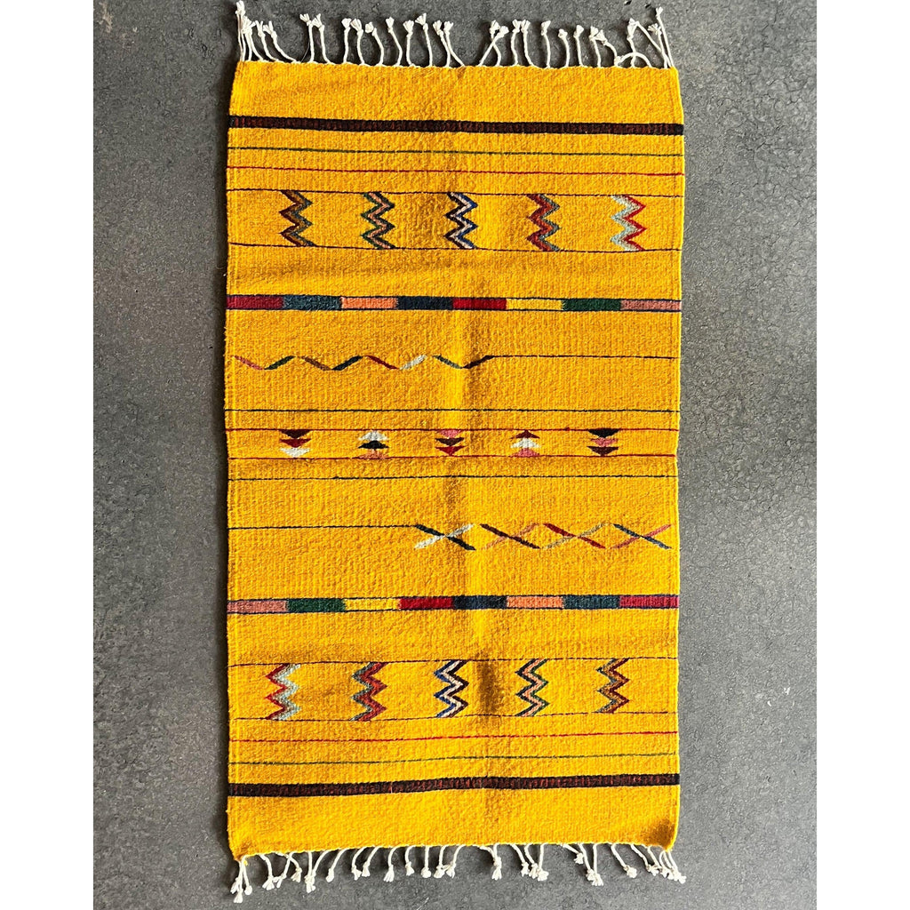 Studio CM | yellow zapotec rug with fringe ends decorated with vibrant traditional symbols